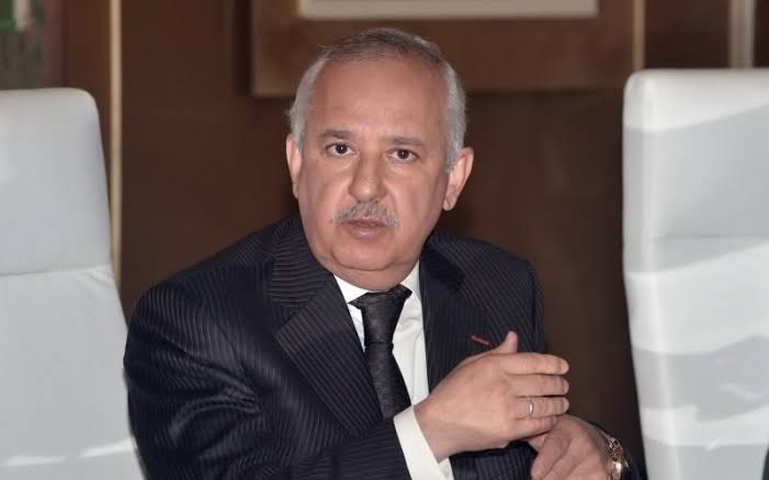 Anas Sefrioui seated between white chairs in a Groupe Addoha boardroom